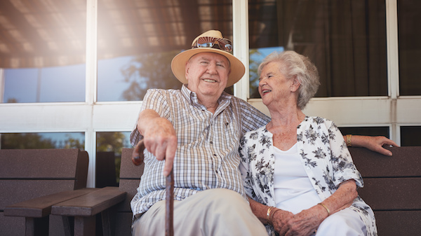 elderly couple sitting outside on a sunny day